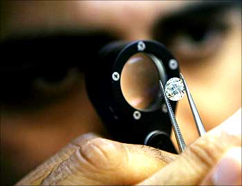 An employee inspects diamonds while grading them at a diamond merchant's workshop.