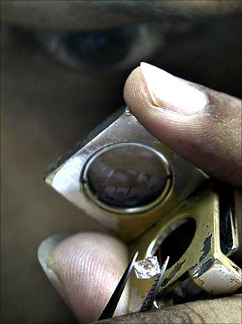 An employee inspects diamonds while grading them.