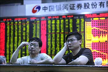 Two man read information on an electronic screen at a brokerage house in Shanghai.
