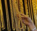 Gold slides to 2-year low on weak global cues, down Rs 300