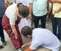 Rahul ties mother's shoelaces as she walks besides him