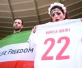 Security escort fans wearing pro-Iran protest shirt