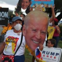 Dina Romero holds a cutout of Democratic presidential nominee Joe Biden with other people showing their support outside of the Miami-Dade County Elections Department in Doral, Florida