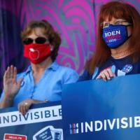 Activists hold signs as they attend a news conference to demand respect for the results of the 2020 US presidential election, in Phoenix, Arizona