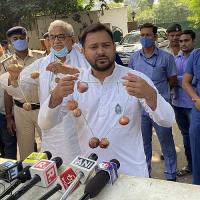 Tejashwi Yadav with a garland of onions to highlight escalating prices