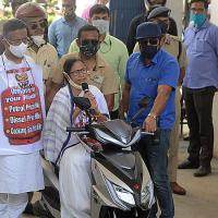 Mamata sits astride an electric scooter at Nabanna