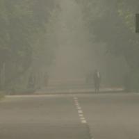 A man walks through a haze this morning