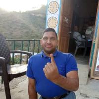 A specially-baled voter shows his ink-marked finger in Solan