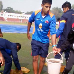 Desperate Mumbai players help in drying outfield at Railways ground