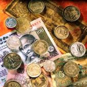 Rupee down by 14 paise to 56.11 vs dollar