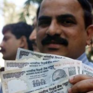 Rupee trims early gains vs dollar, still up 13 paise