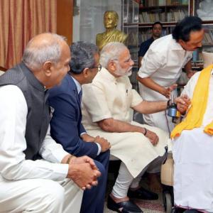 In show of warmth, Modi sits next to Karunanidhi, holds his hands