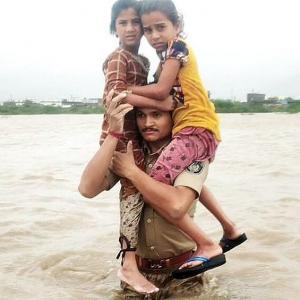 Guj cop carries 2 children on shoulders in floodwater