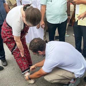 Rahul ties mother's shoelaces as she walks besides him