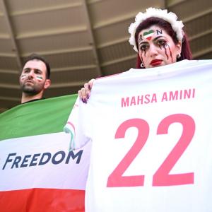 Security escort fans wearing pro-Iran protest shirt