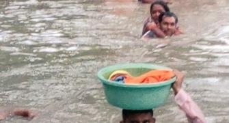Cop carries baby in tub on his head in neck-deep water