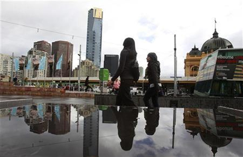Office workers walk through Federation Square in Melbourne.