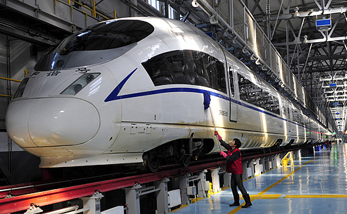 A worker cleans a CRH380B high-speed Harmony bullet train as it stops for an examination during a test run, at a bullet train exam and repair center in Shenyang, Liaoning province.