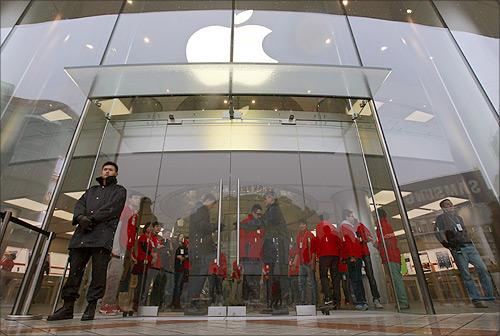 Security guards and staff stand at the entrance of an Apple store during the release of iPhone 5 in Beijing's Wangfujing shopping district.