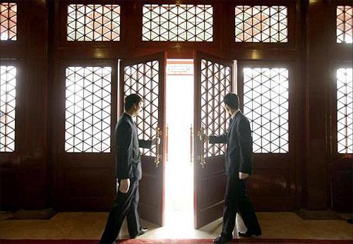 Waiters open a Chinese traditional red door inside a luxurious furniture museum in Beijing.