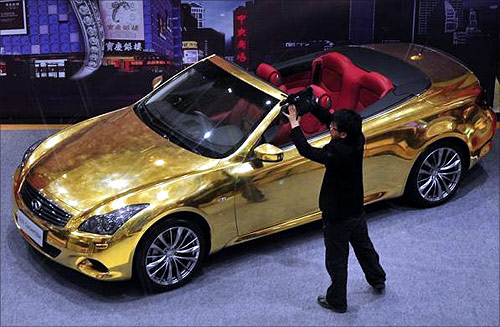 A man films a gold-plated Infiniti G37 at a jewellery store in Nanjing, Jiangsu province.
