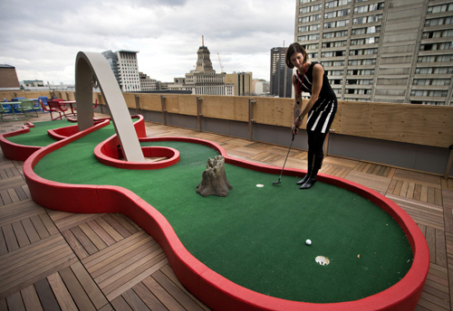 Google employee Andrea Janus demonstrates the use of the mini-putt green on the balcony at the new Google office in Toronto.