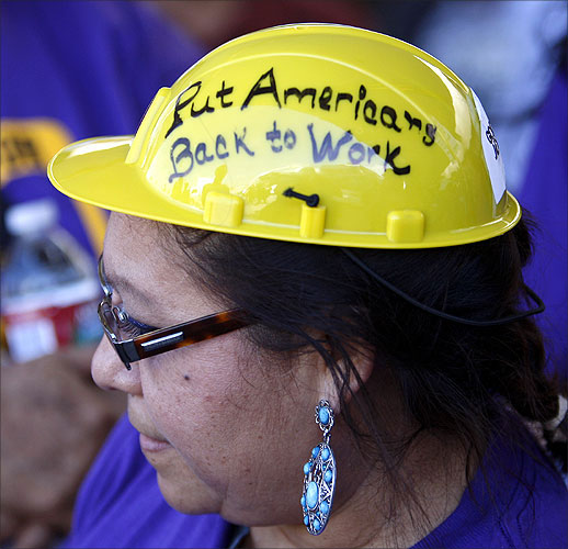 Protester Victoria Marquez wears a hard hat with the message to put Americans back to work.