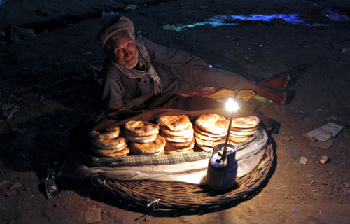 An Afghan man sells bread along a street as he waits for customers at the old part of Kabul.
