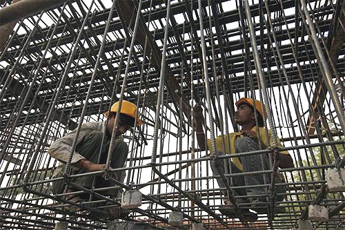 Labourers work at a flyover construction site in Mumbai.