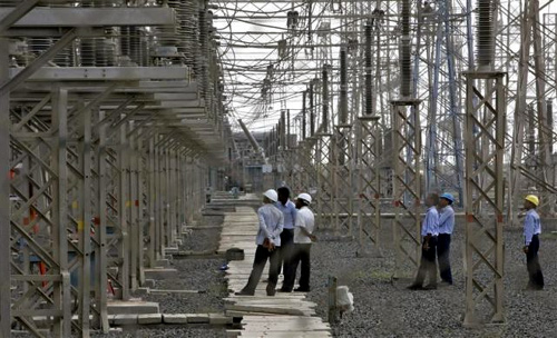 Engineers inspect electric transmission lines at Adani Power Company thermal power plant at Mundra in Gujarat.