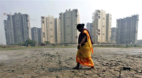 A woman labourer walks past a residential estate under construction in Kolkata.