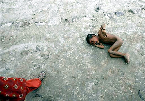 A girl lies on the ground as she cries for food in Akhera village in Haryana.