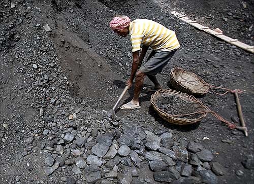 Labourers rest at a coal yard at Bari Brahamina on the outskirts of Jammu.