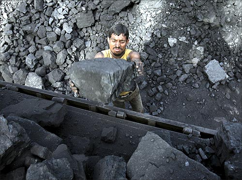 A labourer loads coal onto a truck at a coal yard on the outskirts of Jammu.