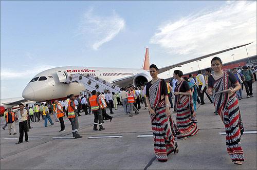 Air hostesses walk next to the parked Air India's Boeing 787-800 Dreamliner upon its arrival at the airport in New Delhi.