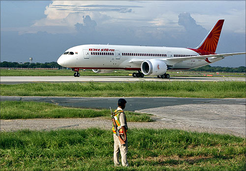 A security personnel stands guard as Air India's Dreamliner Boeing 787 taxies upon its arrival at the airport.