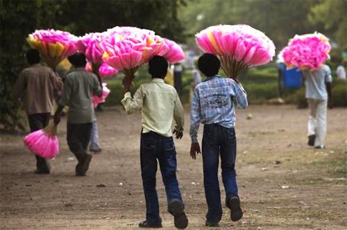 Vendors hold bags of cotton candy for sale as they look for customers in New Delhi.