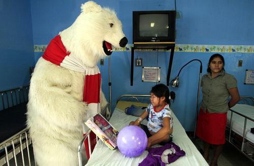 A Coca-Cola polar bear mascot visits a patient at a children's hospital in Managua.