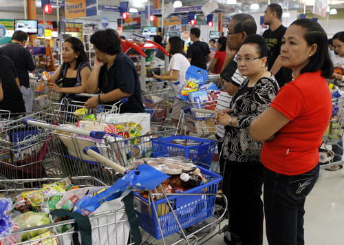 People queue to pay for groceries at a supermarket in Paranaque, Metro Manila.