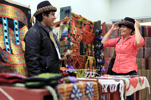 A customer tries a traditional hat made by an Andean man during the