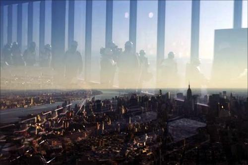 Members of the media are reflected in the windows of the 100th floor observation deck in the One World Trade Center in New York.