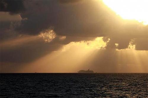 The tugs Resolve Pioneer and Dabhol tow and steer the Carnival Triumph cruise ship in the Gulf of Mexico to Mobile, Alabama, following an engine room fire.