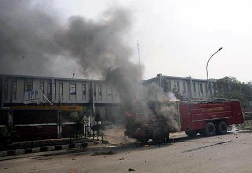 A fire engine is seen in flames after it was set afire by protesters during a strike in Noida on the outskirts of New Delhi February 20, 2013.