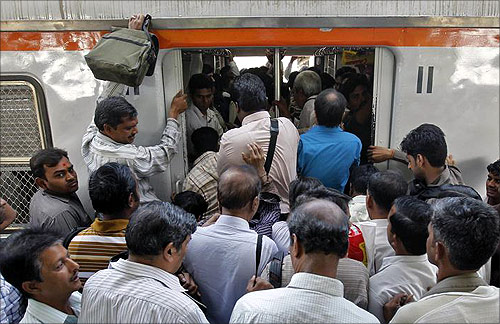 Commuters try to get in an overcrowded train on a railway platform in Mumbai.