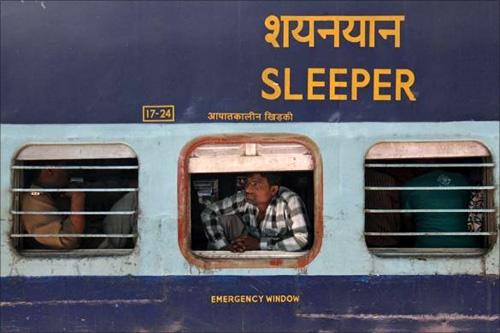 A man looks out of a compartment of the Kalka Mail passenger train at a railway station in Firozabad