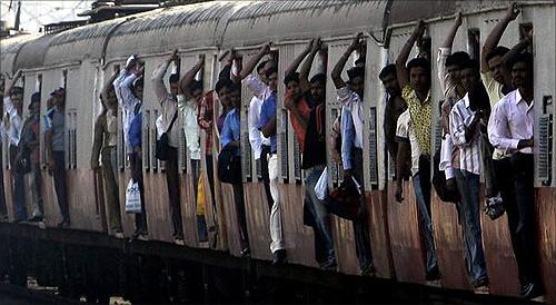 Passengers travel in a crowded suburban train at a railway station in Mumbai.