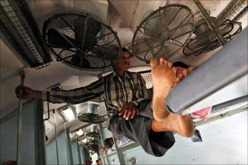 A man sits on a berth inside the sleeper class compartment of the Kalka Mail passenger train on the way to Kolkata.