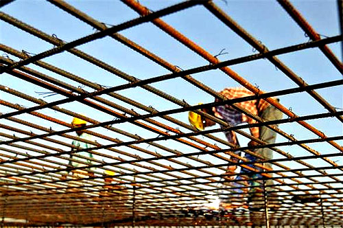 A worker welds iron rods at the construction site of a commercial complex in Ahmedabad.