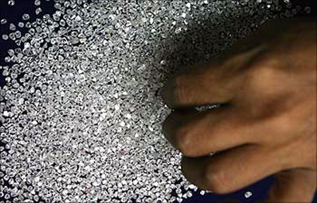 An employee sifts diamonds at a diamond cutting and polishing factory in Surat.