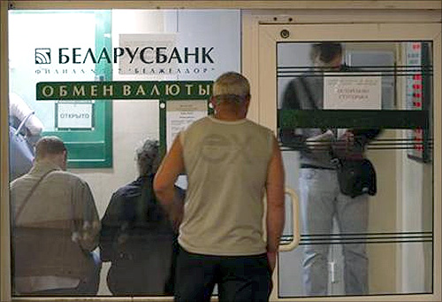 People wait to buy foreign currency inside an exchange office of the Belarus bank in Minsk.